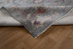 Vintage floral rug with faded botanical pattern in muted blue and rose tones