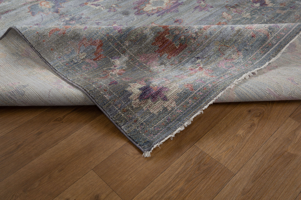 Vintage floral rug with faded botanical pattern in muted blue and rose tones