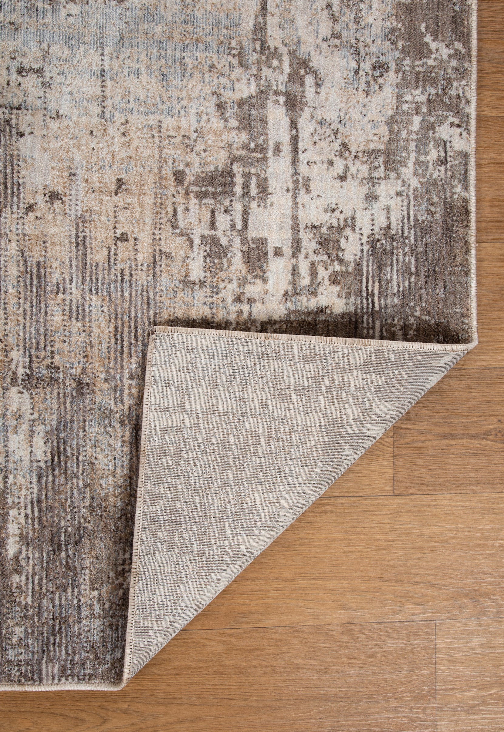 Distressed beige and brown textured rug with abstract streaked pattern