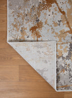 Modern distressed rug with gold, gray and cream abstract splatter pattern design
