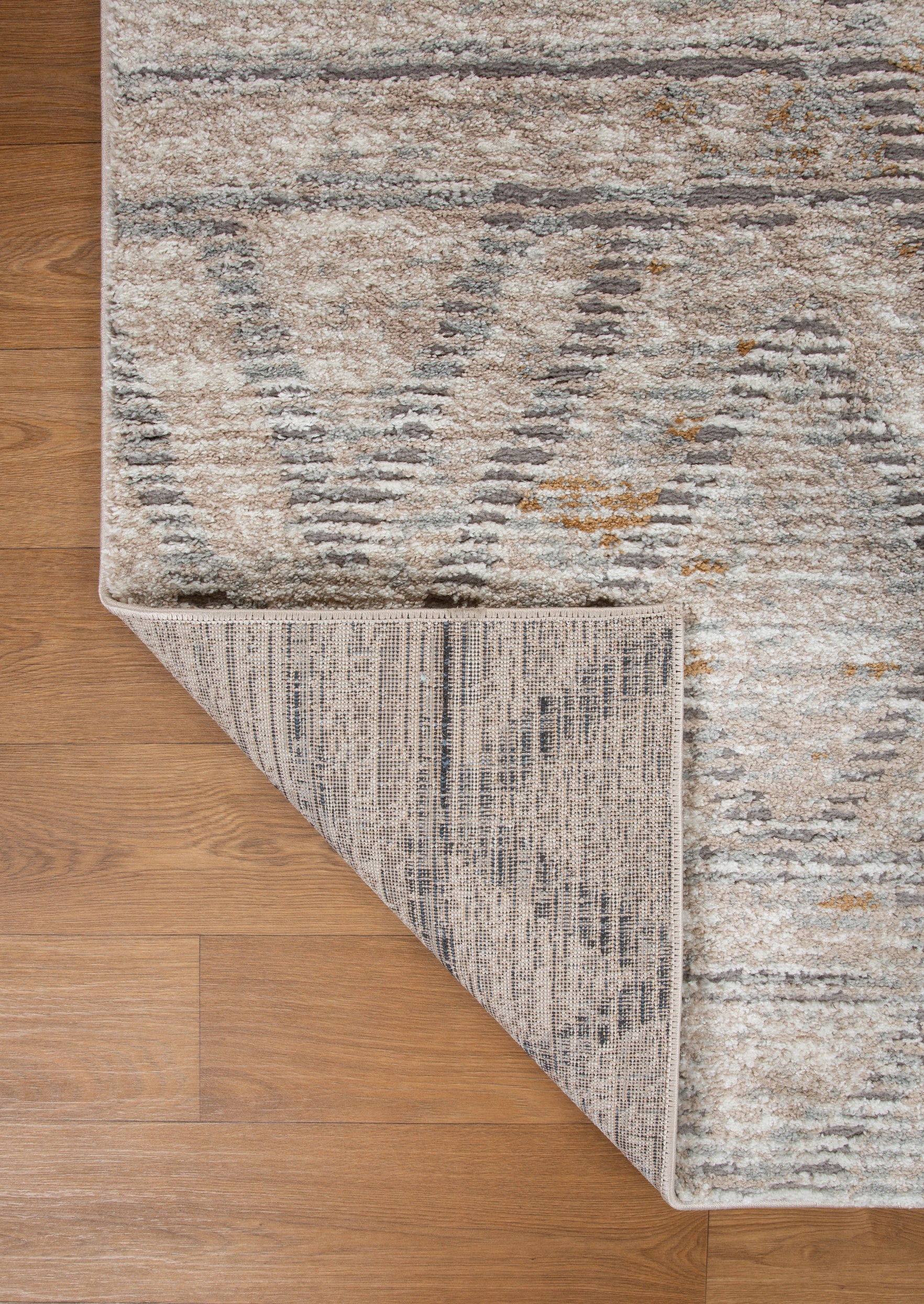 Modern geometric patterned rug in soft beige, grey and gold tones