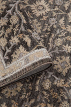 Charcoal and beige damask patterned rug with ornate floral motifs and border