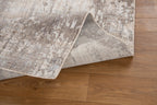 Distressed beige and brown textured rug with abstract streaked pattern