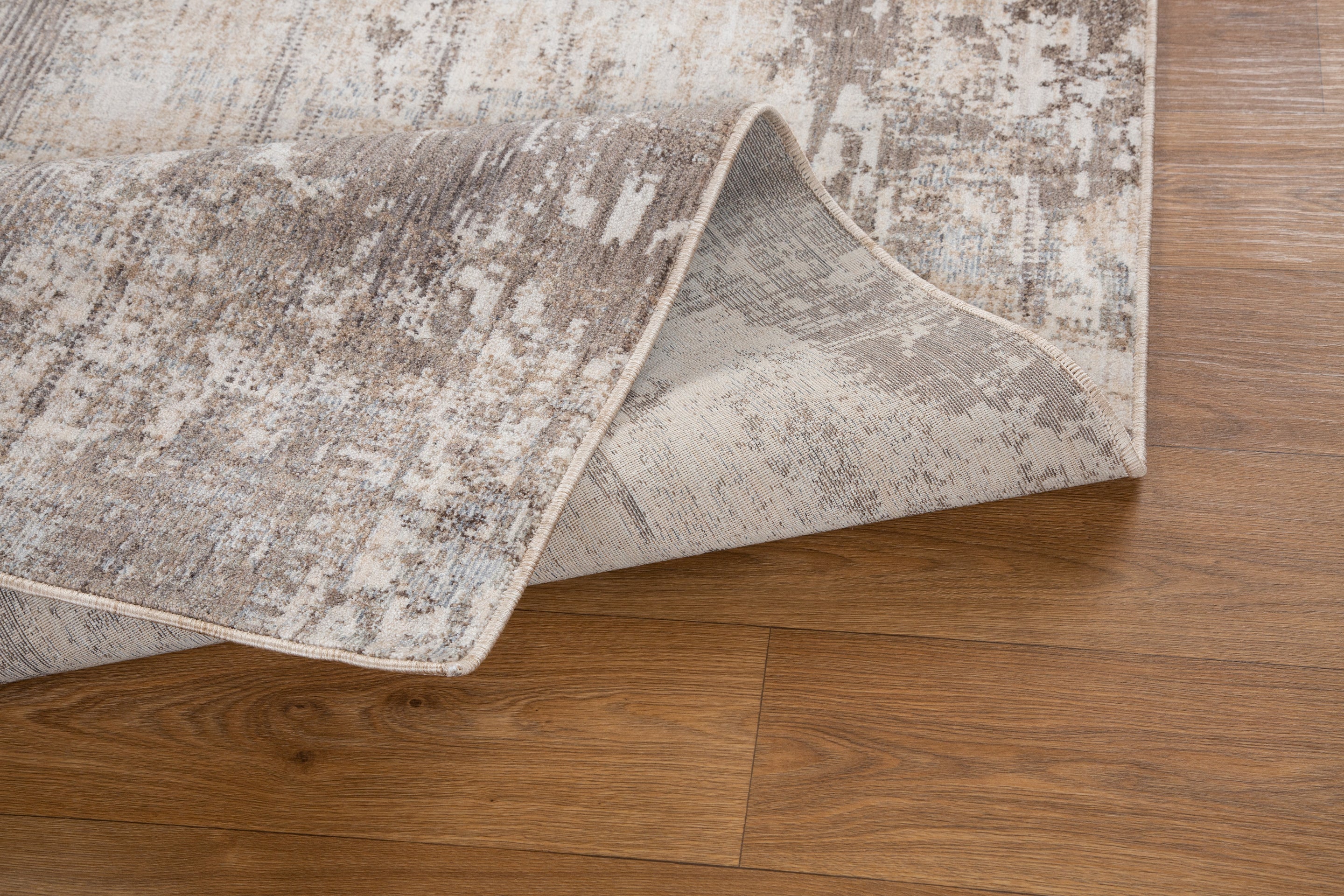 Distressed beige and brown textured rug with abstract streaked pattern