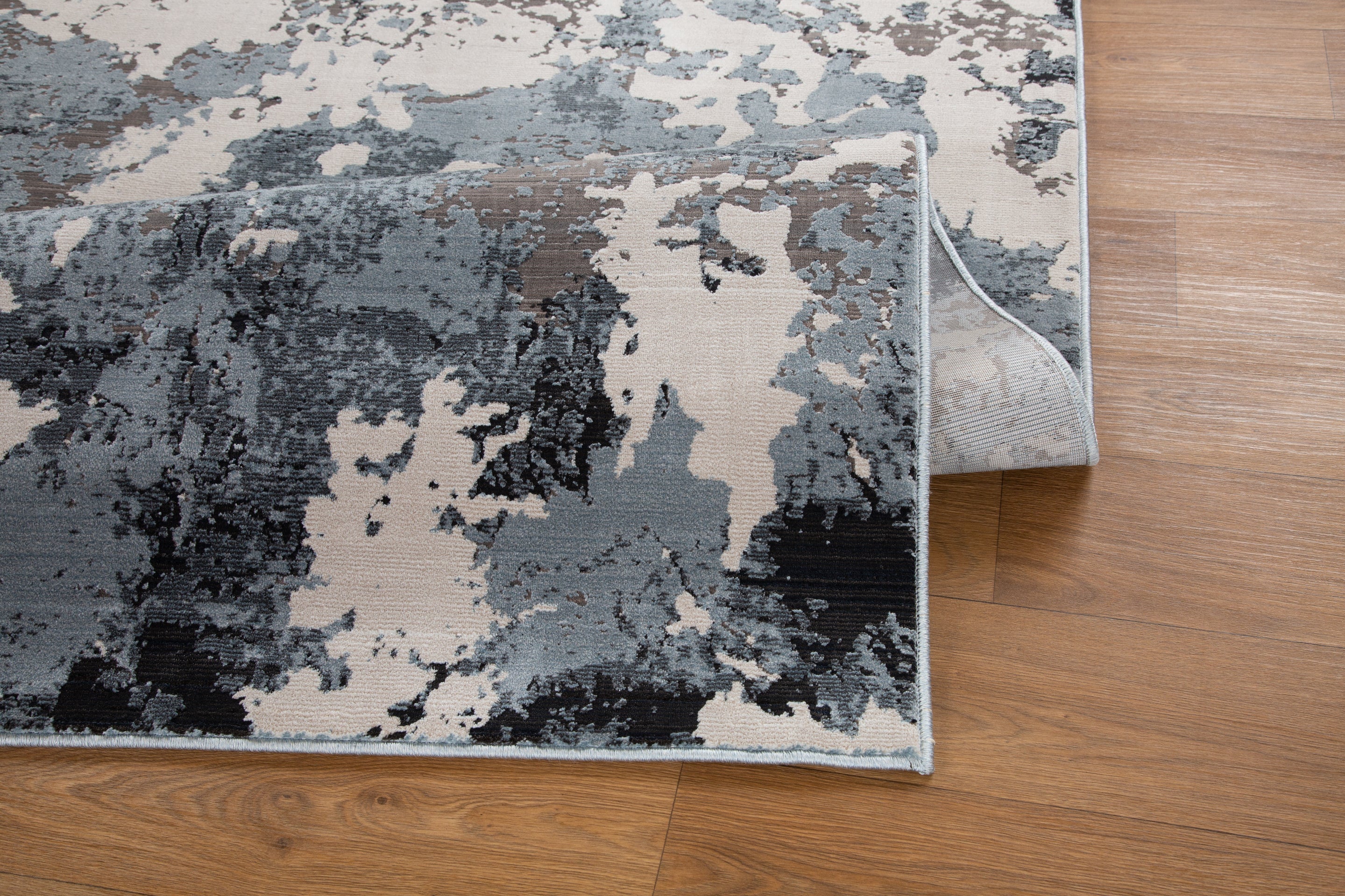 Modern distressed area rug with blue, grey and cream abstract paint splatter pattern