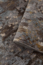 Abstract distressed rug with gold, grey, and brown pixelated pattern texture