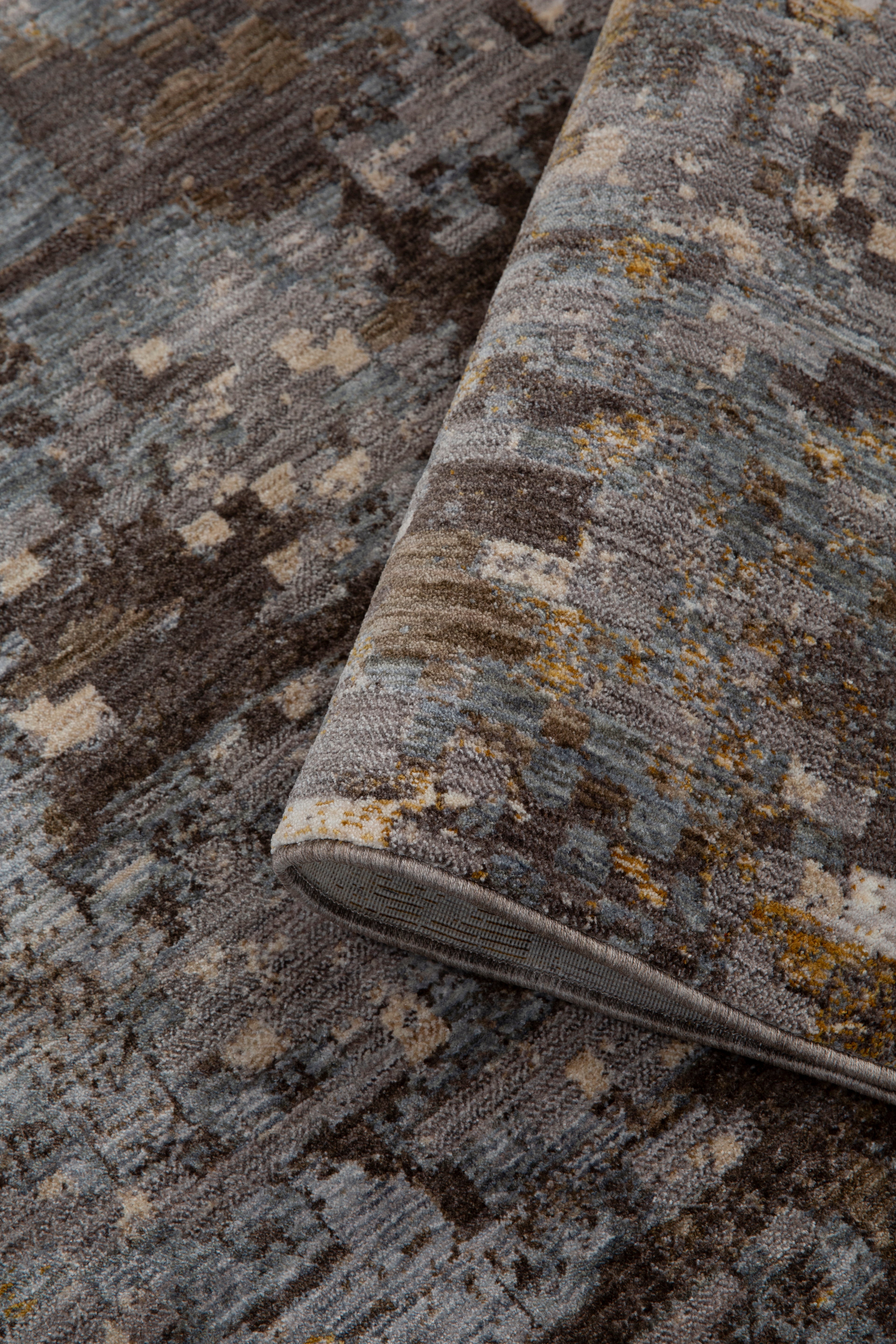 Abstract distressed rug with gold, grey, and brown pixelated pattern texture