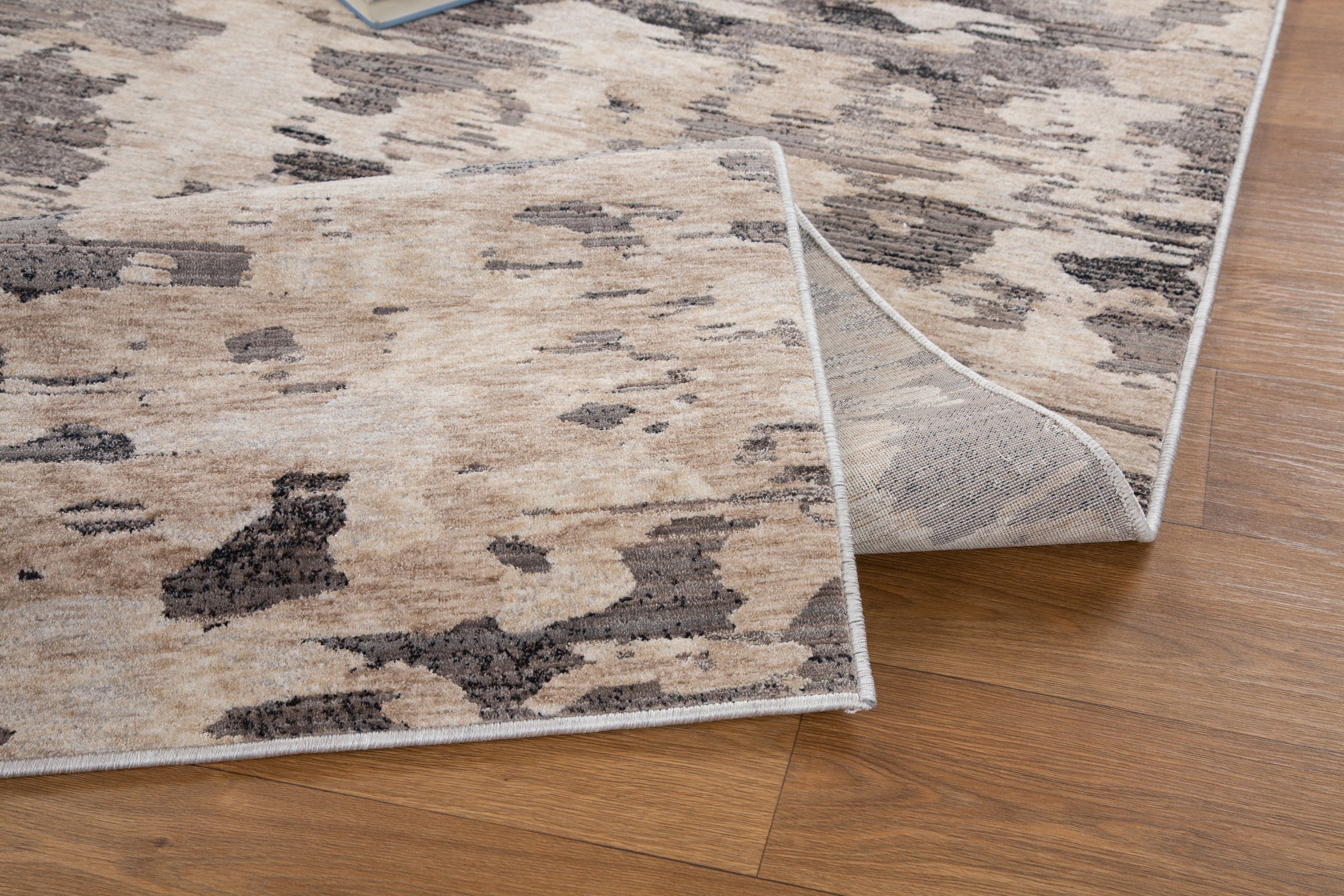 Blue book on gray and white striped wool rug with textured surface