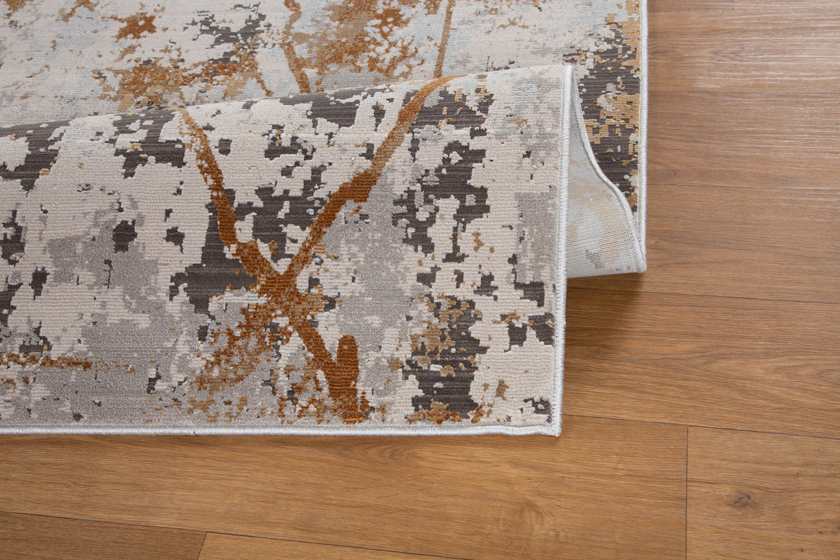Modern distressed rug with gold, gray and cream abstract splatter pattern design