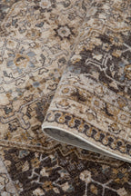 Vintage-style area rug with beige and brown geometric patterns and ornate borders