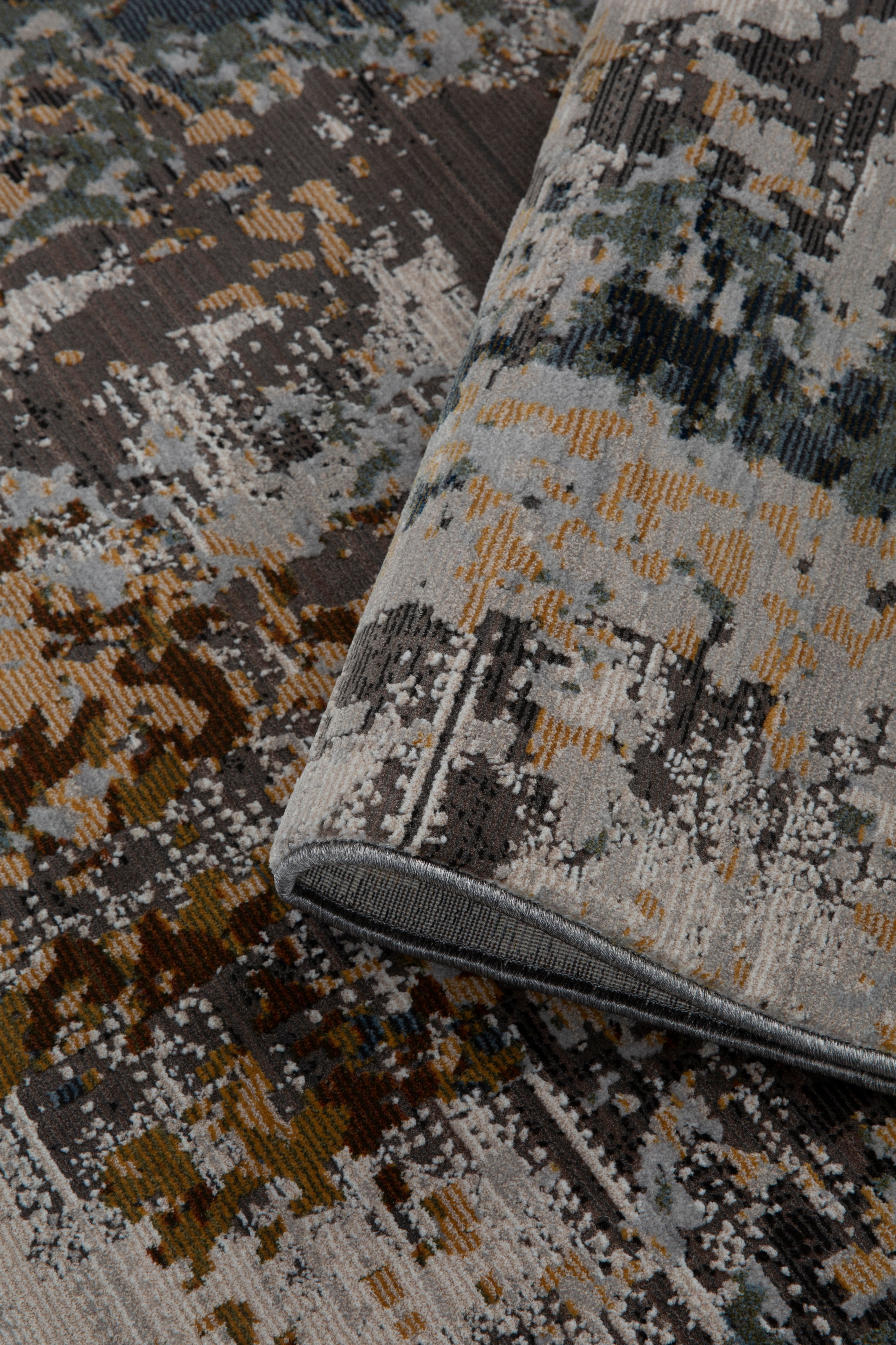Abstract distressed rug with gold, gray, and black splatter pattern design