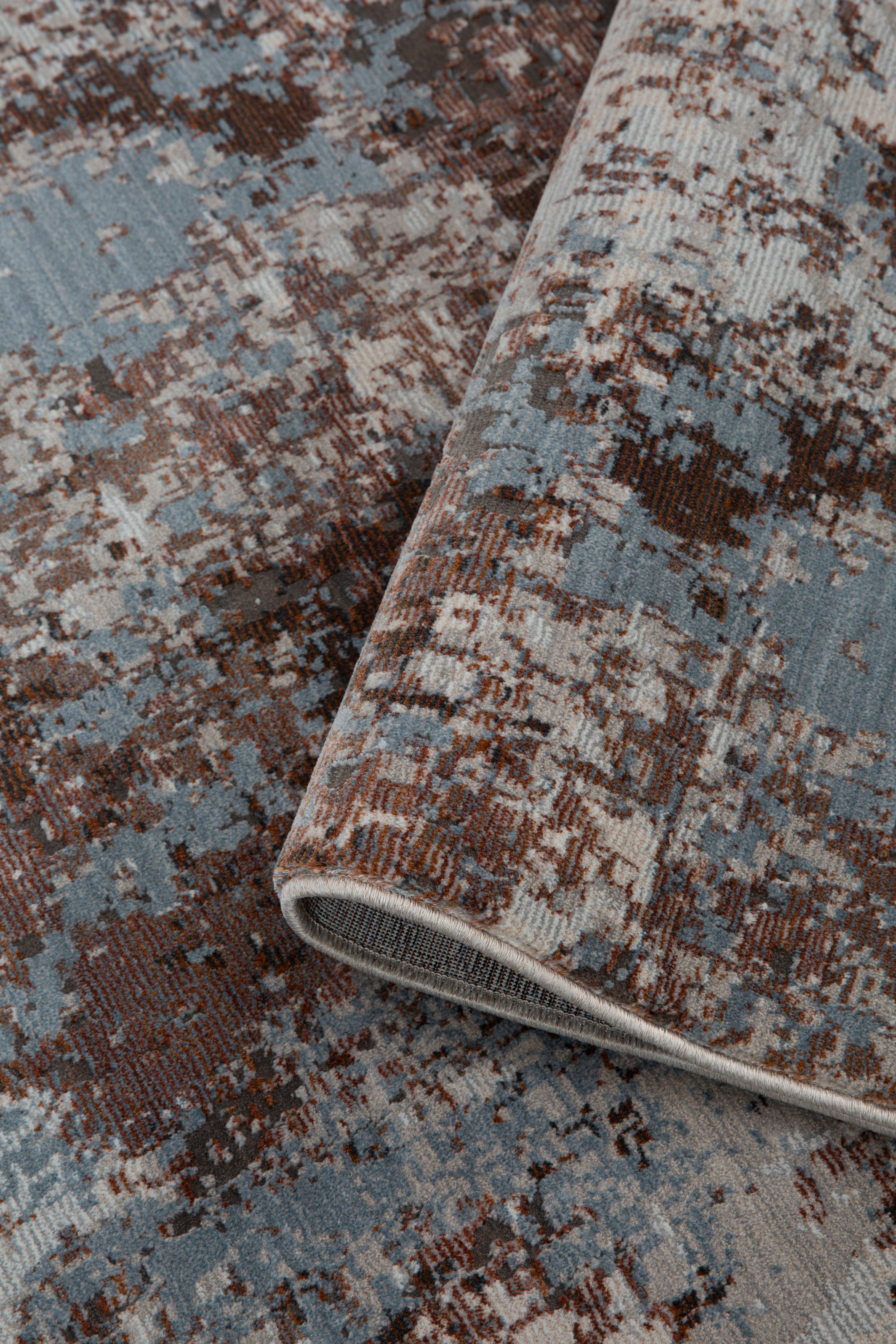 Modern distressed rug with brown, cream and blue abstract texture pattern