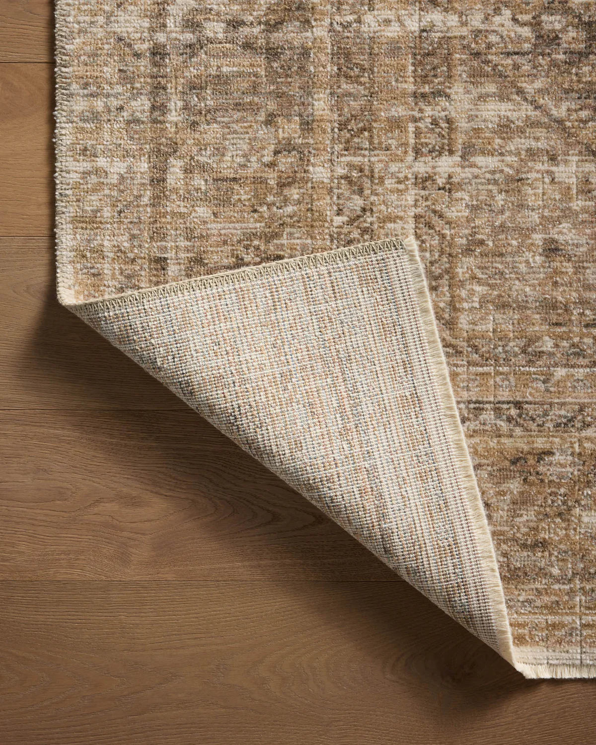 Beige traditional area rug with ornate border and distressed vintage pattern