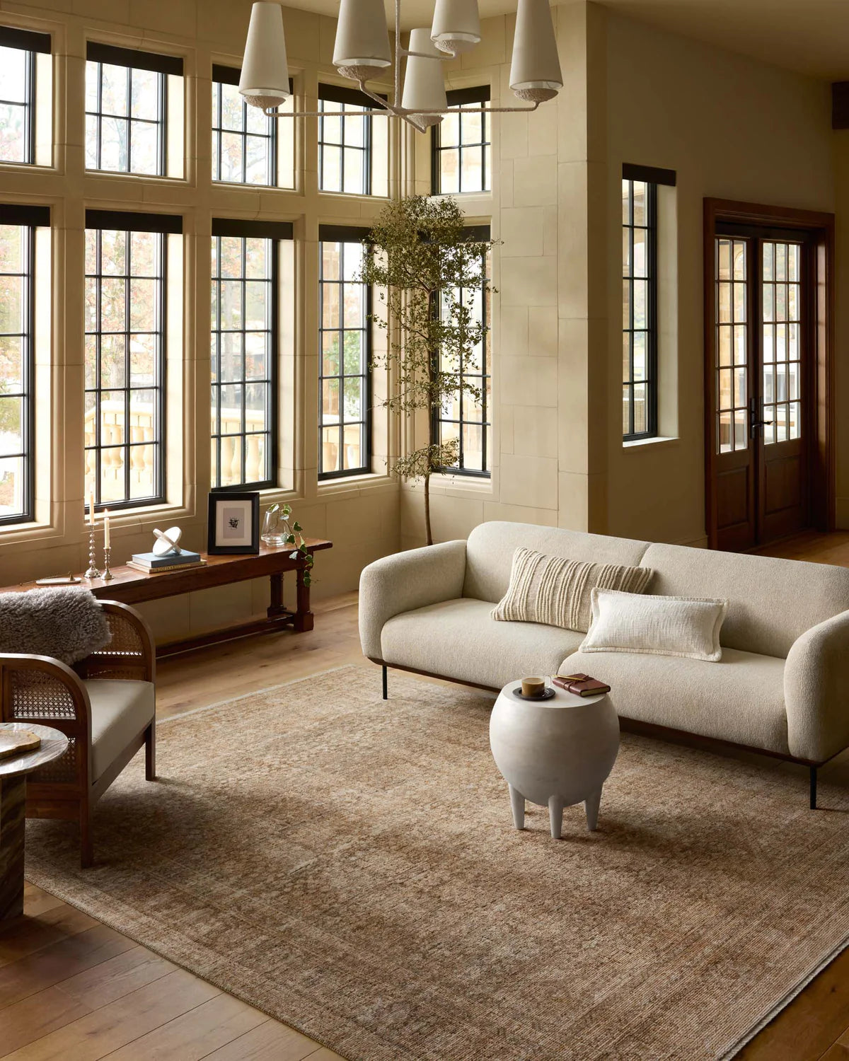 Beige traditional area rug with ornate border and distressed vintage pattern