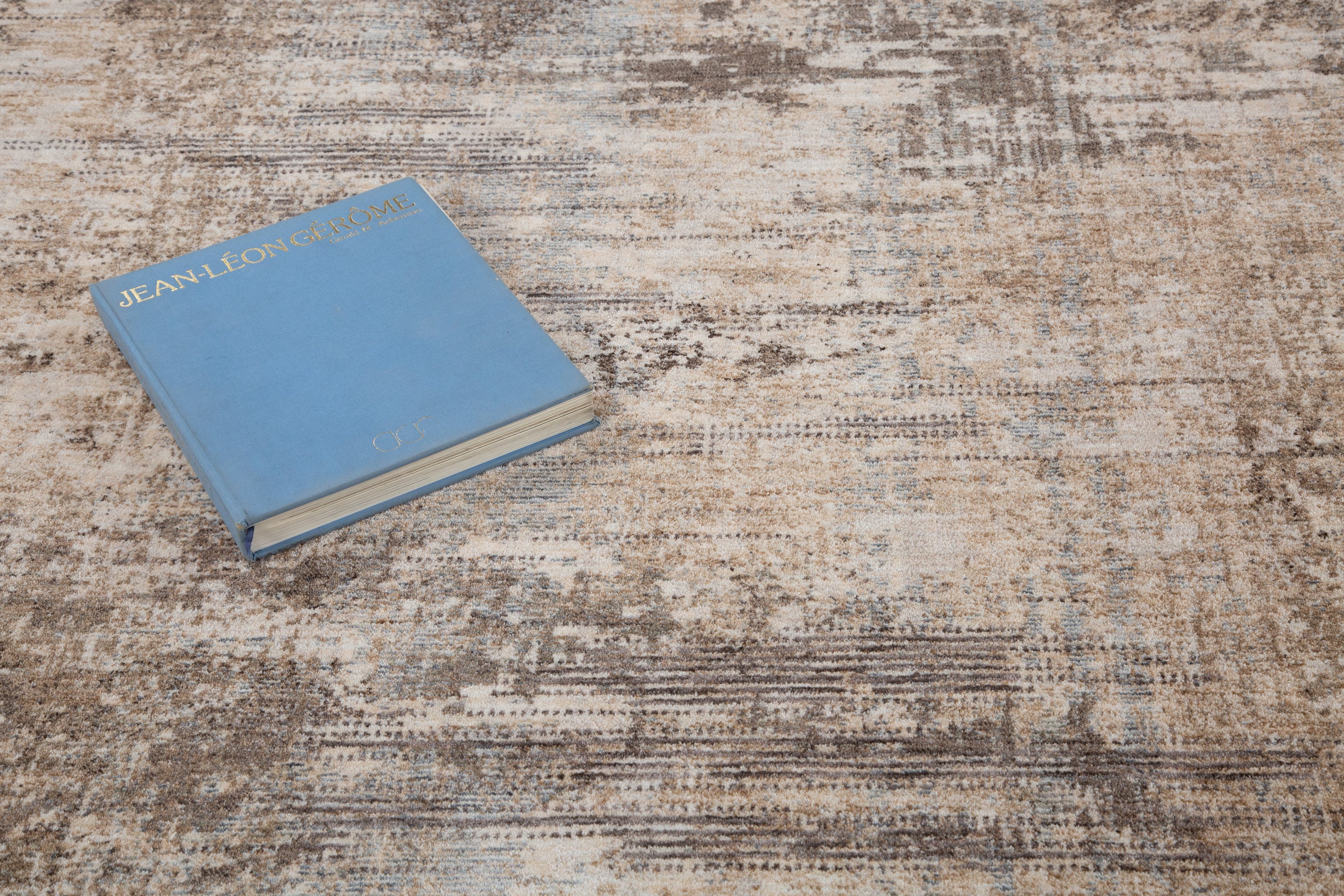 Distressed beige and brown textured rug with abstract streaked pattern