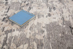 Blue book on gray and white striped wool rug with textured surface
