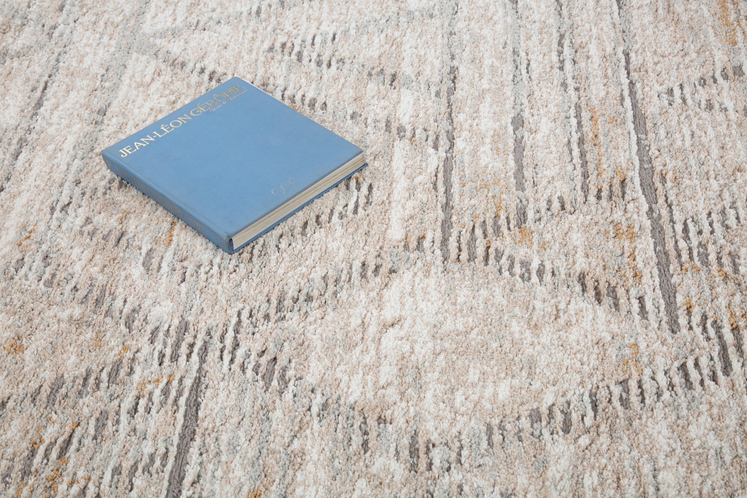 Modern geometric patterned rug in soft beige, grey and gold tones