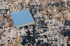 Abstract distressed rug with navy, rust, and cream textured pattern