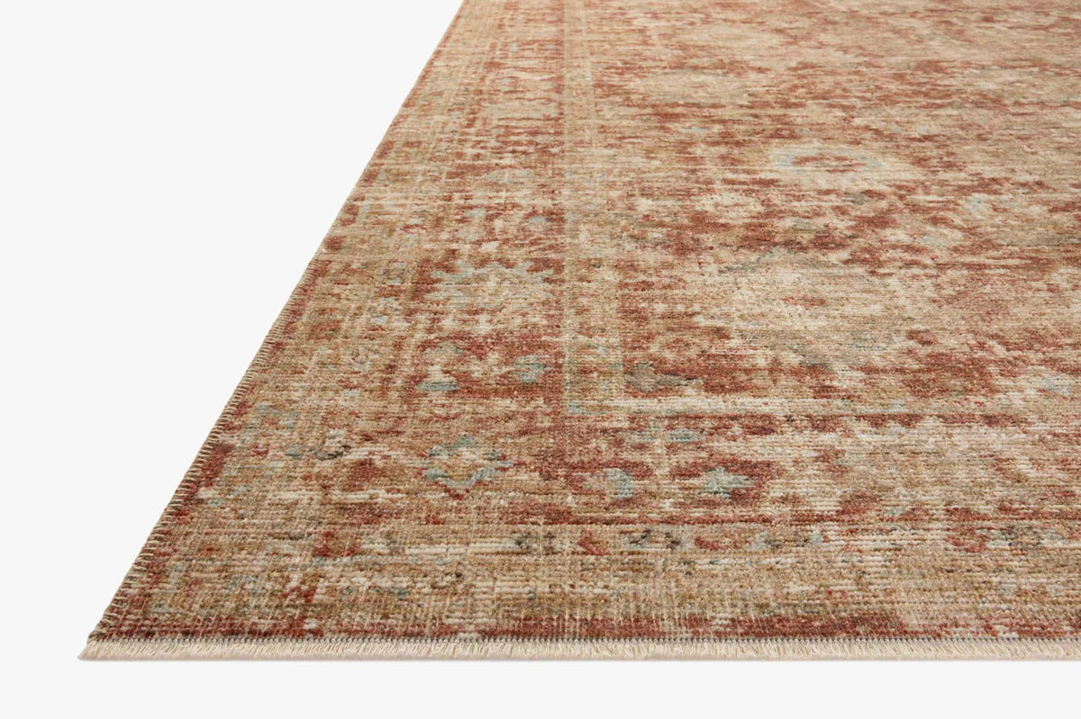 Vintage-style rug with faded terracotta and beige distressed floral pattern throughout