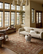 Vintage-style rug with faded terracotta and beige distressed floral pattern throughout