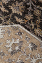 Charcoal and beige damask patterned rug with ornate floral motifs and border