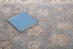Gray traditional rug with ornate cream border and floral damask pattern