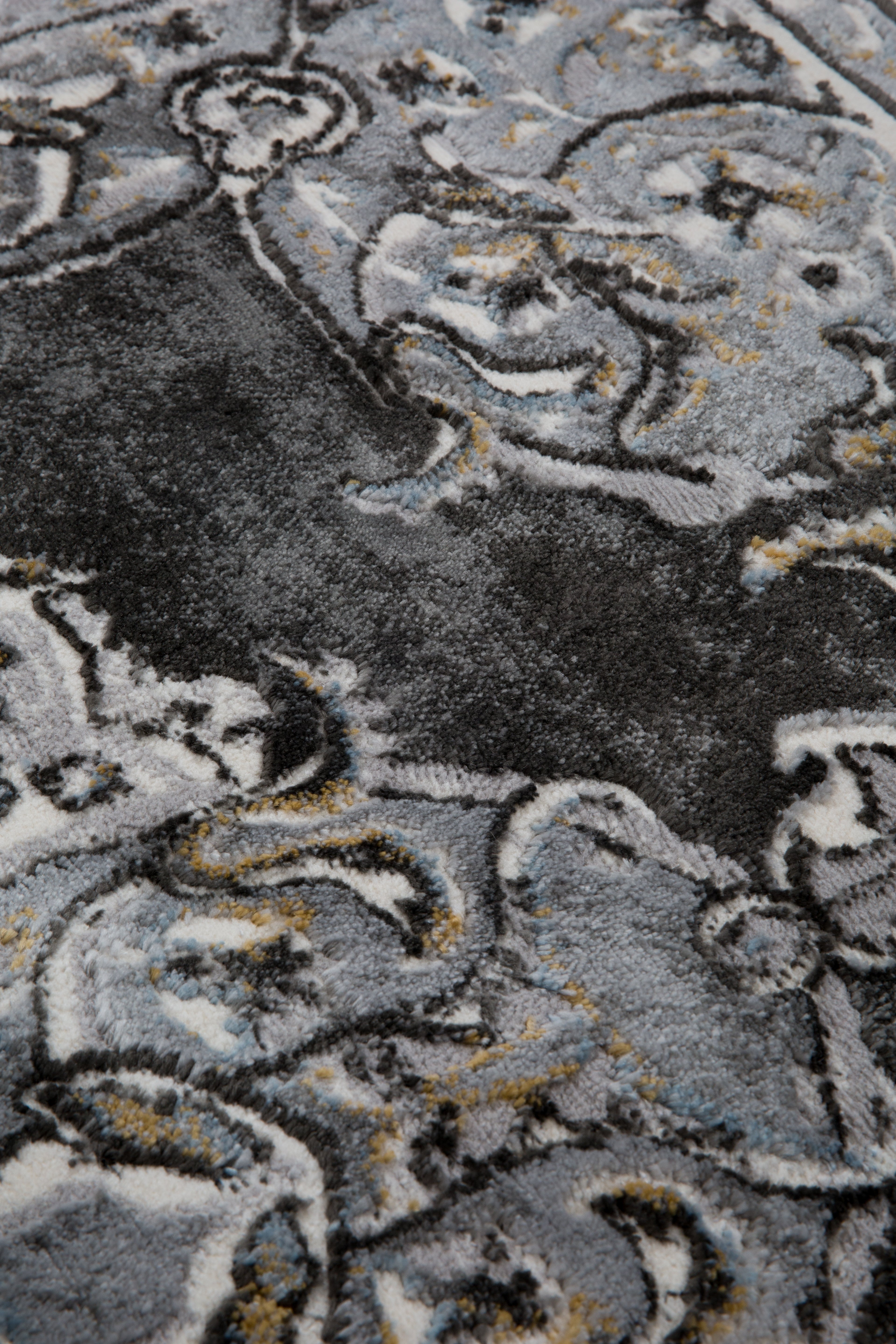 Ornate Persian-style rug with symmetrical medallion pattern in black, gray and cream tones
