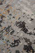 Abstract distressed rug with gold, gray, and black splatter pattern design