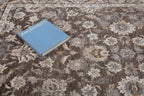 Traditional floral rug with brown center, ornate cream border and botanical pattern design