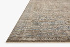 Vintage-style area rug with faded blue and beige geometric patterns throughout