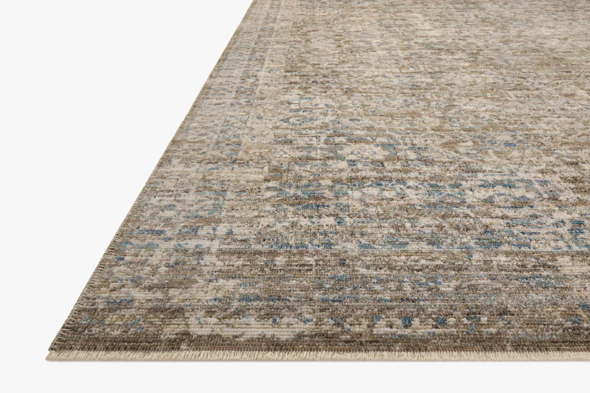 Vintage-style area rug with faded blue and beige geometric patterns throughout