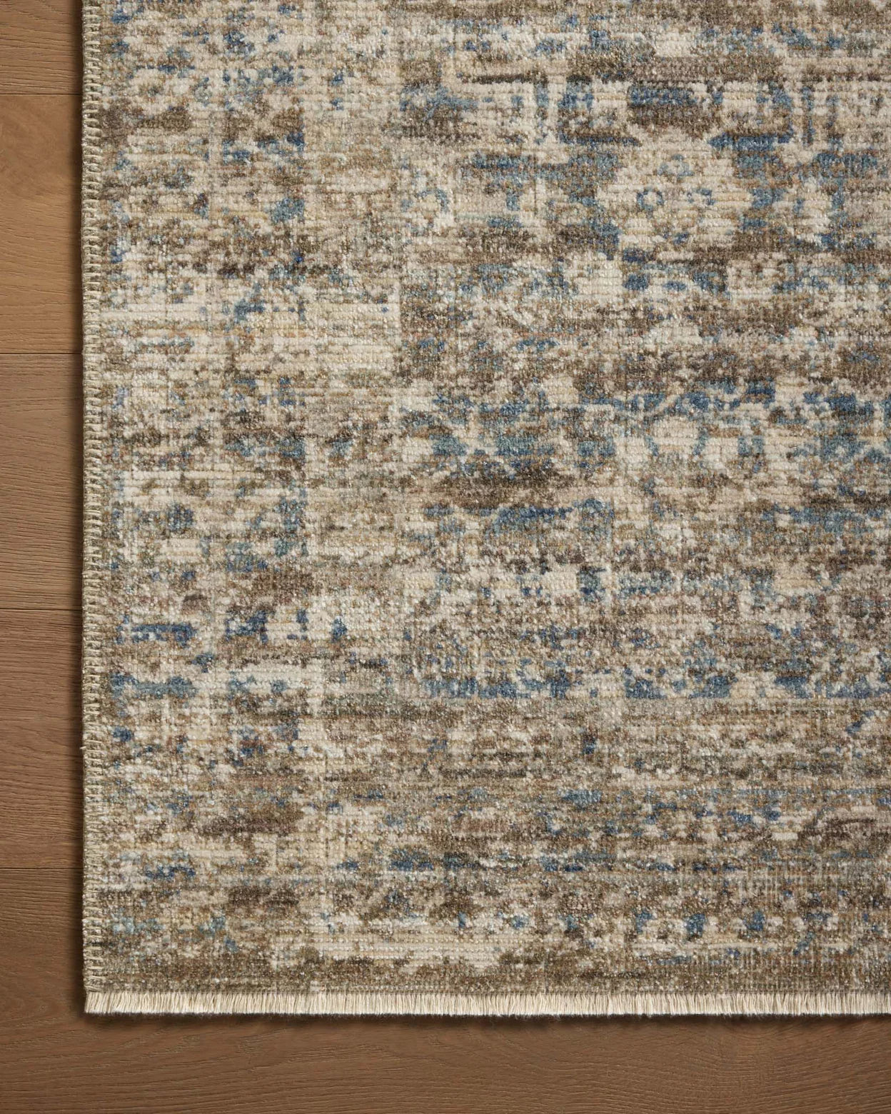 Vintage-style area rug with faded blue and beige geometric patterns throughout