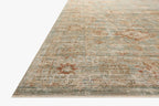 Vintage-style rug with faded rust and cream patterns on soft green background