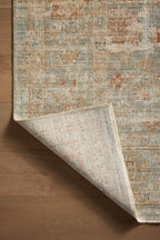 Vintage-style rug with faded rust and cream patterns on soft green background