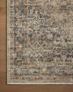 Vintage-style area rug with faded blue and beige geometric patterns throughout
