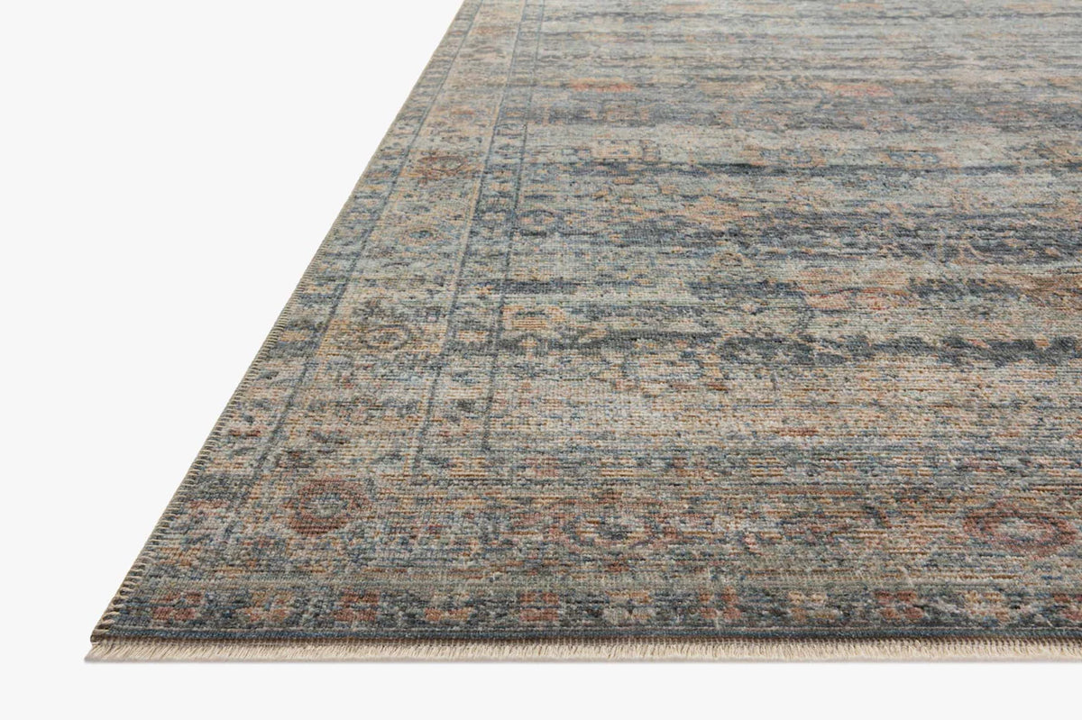 Vintage-style area rug with distressed geometric patterns in blue, tan and grey tones