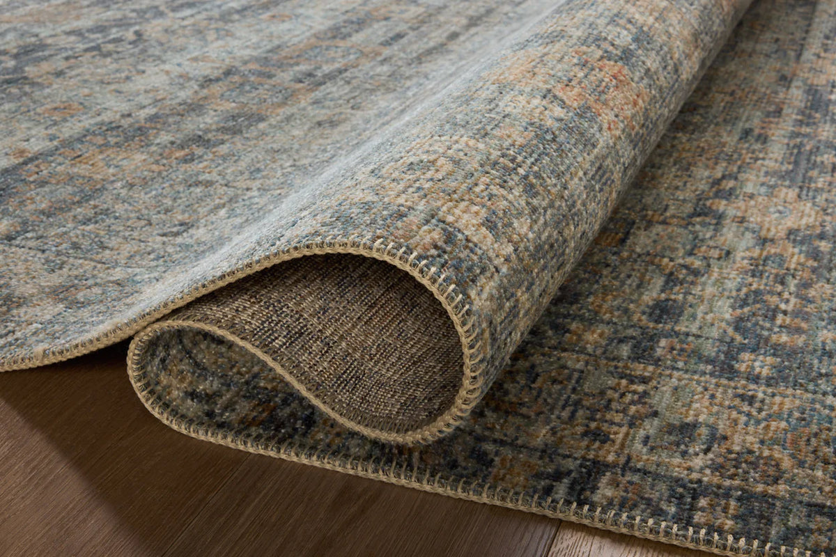 Vintage-style area rug with distressed geometric patterns in blue, tan and grey tones
