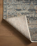 Vintage-style area rug with distressed geometric patterns in blue, tan and grey tones
