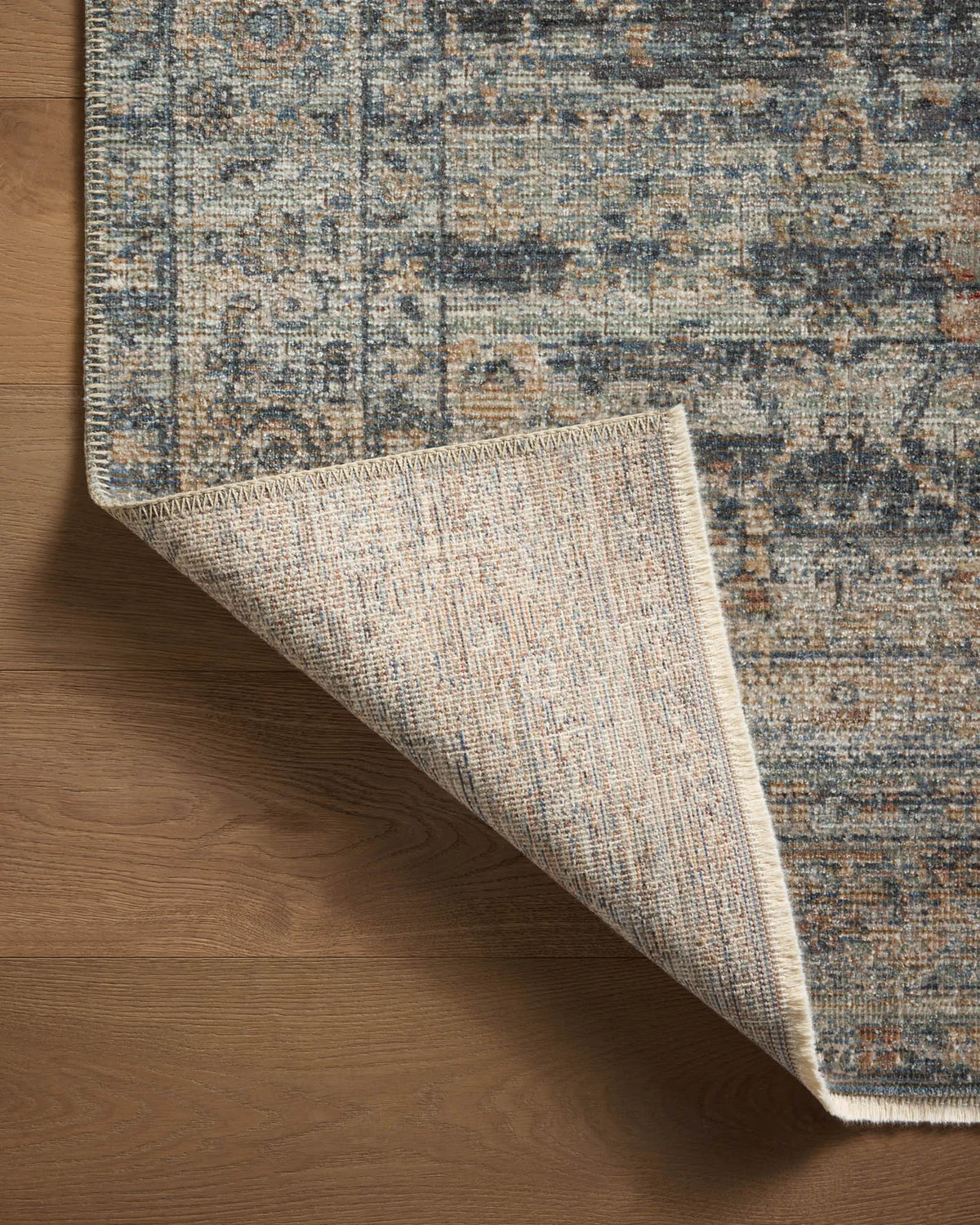 Vintage-style area rug with distressed geometric patterns in blue, tan and grey tones