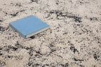 Modern distressed rug with black speckled pattern on cream background texture