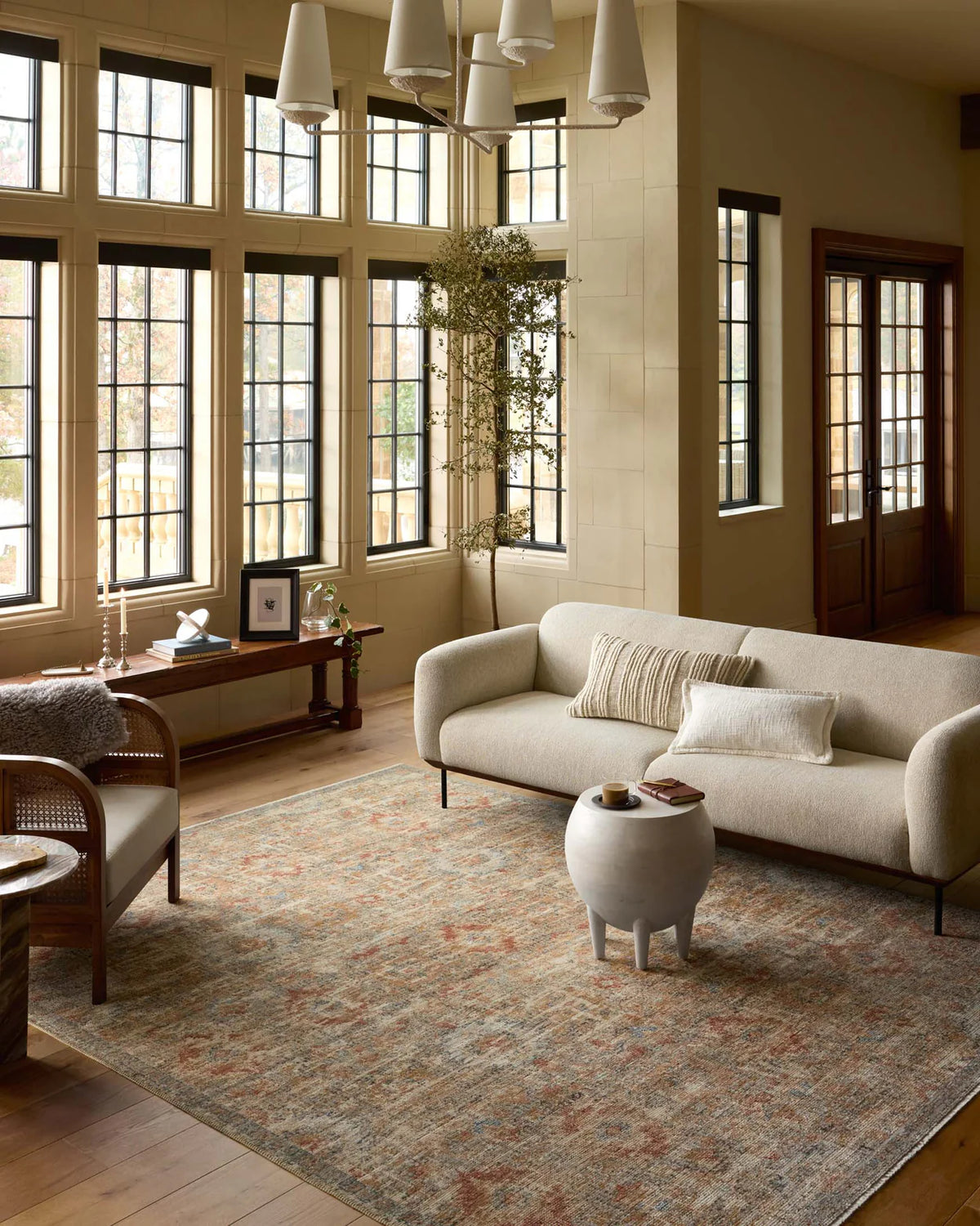 Vintage-style area rug with distressed red and beige geometric patterns on neutral background