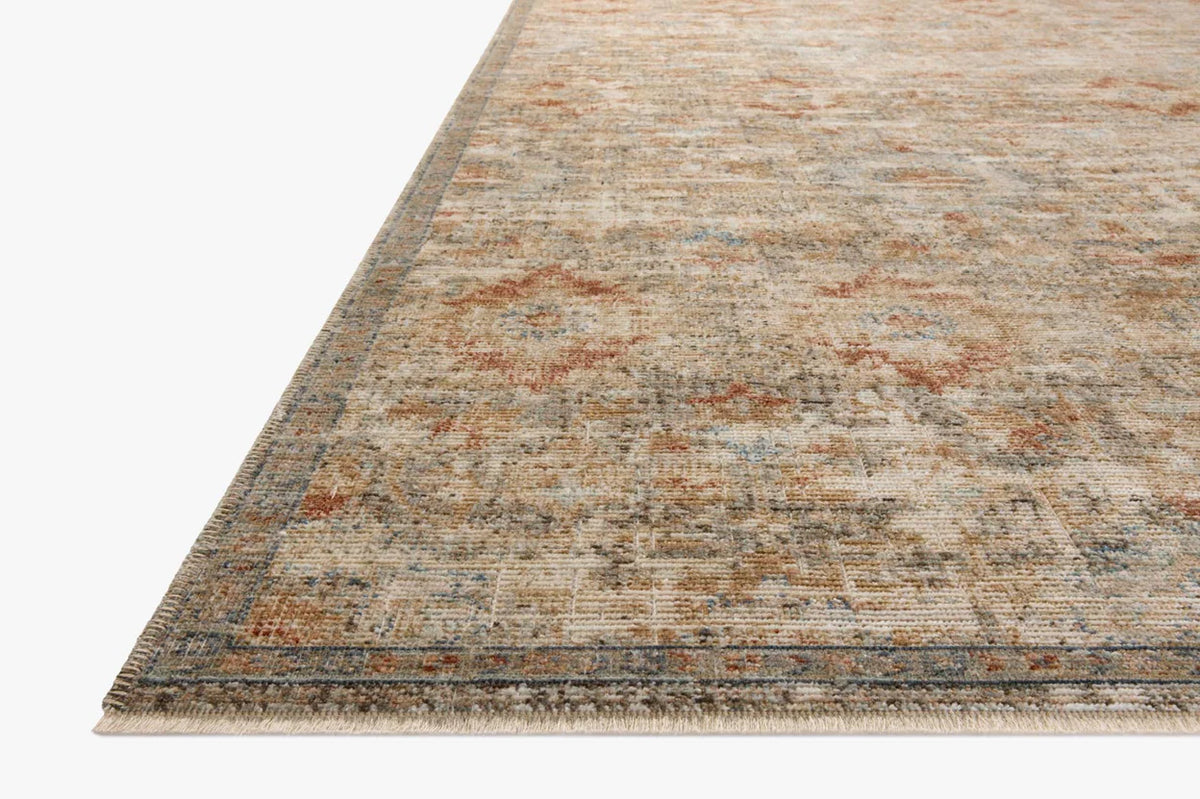 Vintage-style area rug with distressed red and beige geometric patterns on neutral background