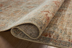 Vintage-style area rug with distressed red and beige geometric patterns on neutral background