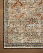 Vintage-style area rug with distressed red and beige geometric patterns on neutral background