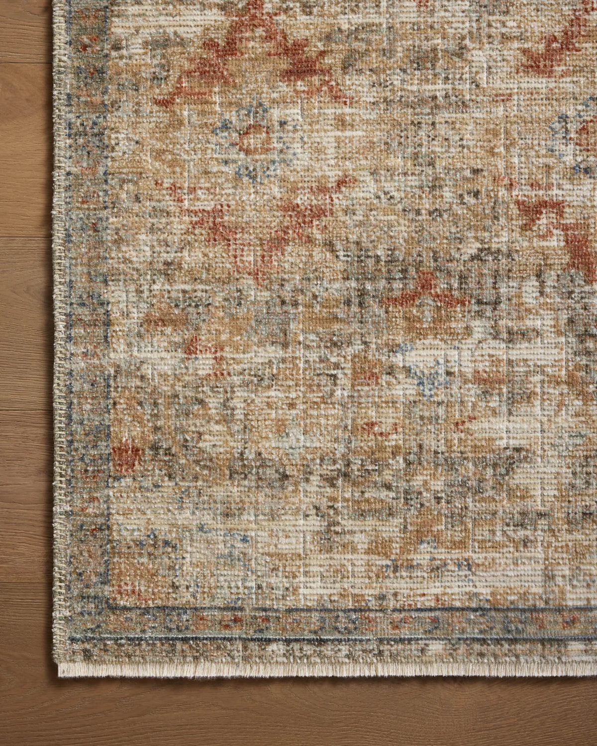 Vintage-style area rug with distressed red and beige geometric patterns on neutral background