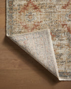 Vintage-style area rug with distressed red and beige geometric patterns on neutral background