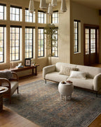 Vintage-style distressed rug with muted grey, tan, and rust tones throughout