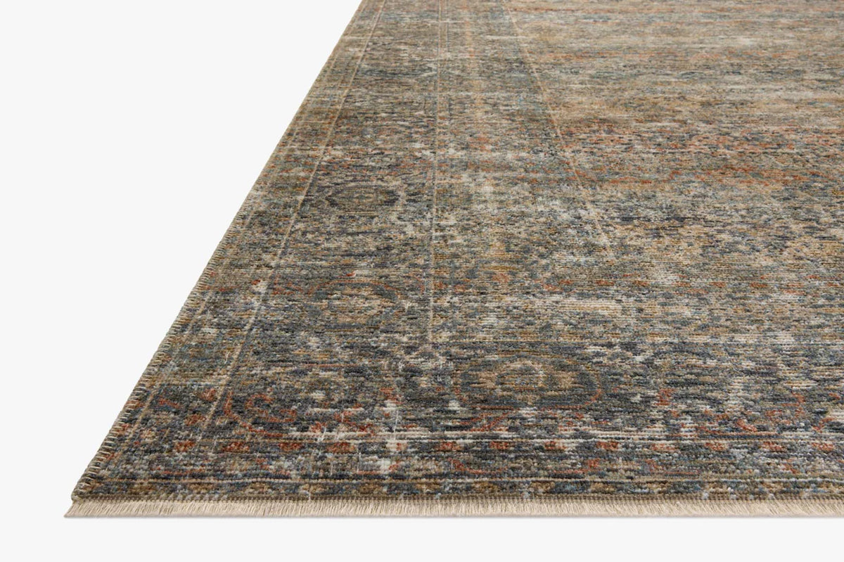 Vintage-style distressed rug with muted grey, tan, and rust tones throughout