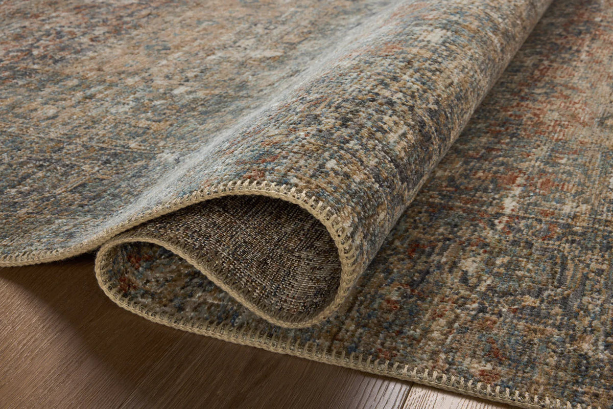 Vintage-style distressed rug with muted grey, tan, and rust tones throughout