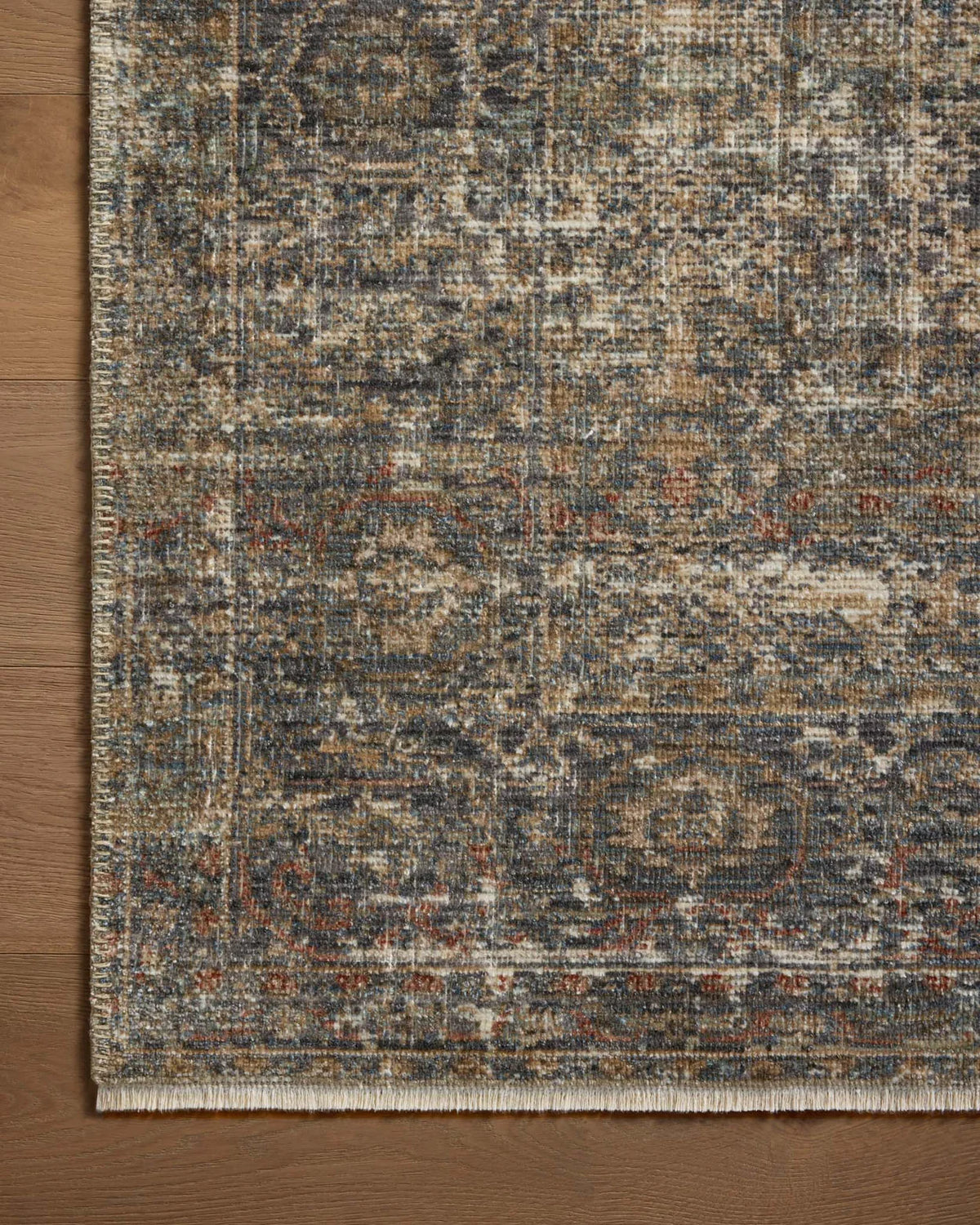 Vintage-style distressed rug with muted grey, tan, and rust tones throughout